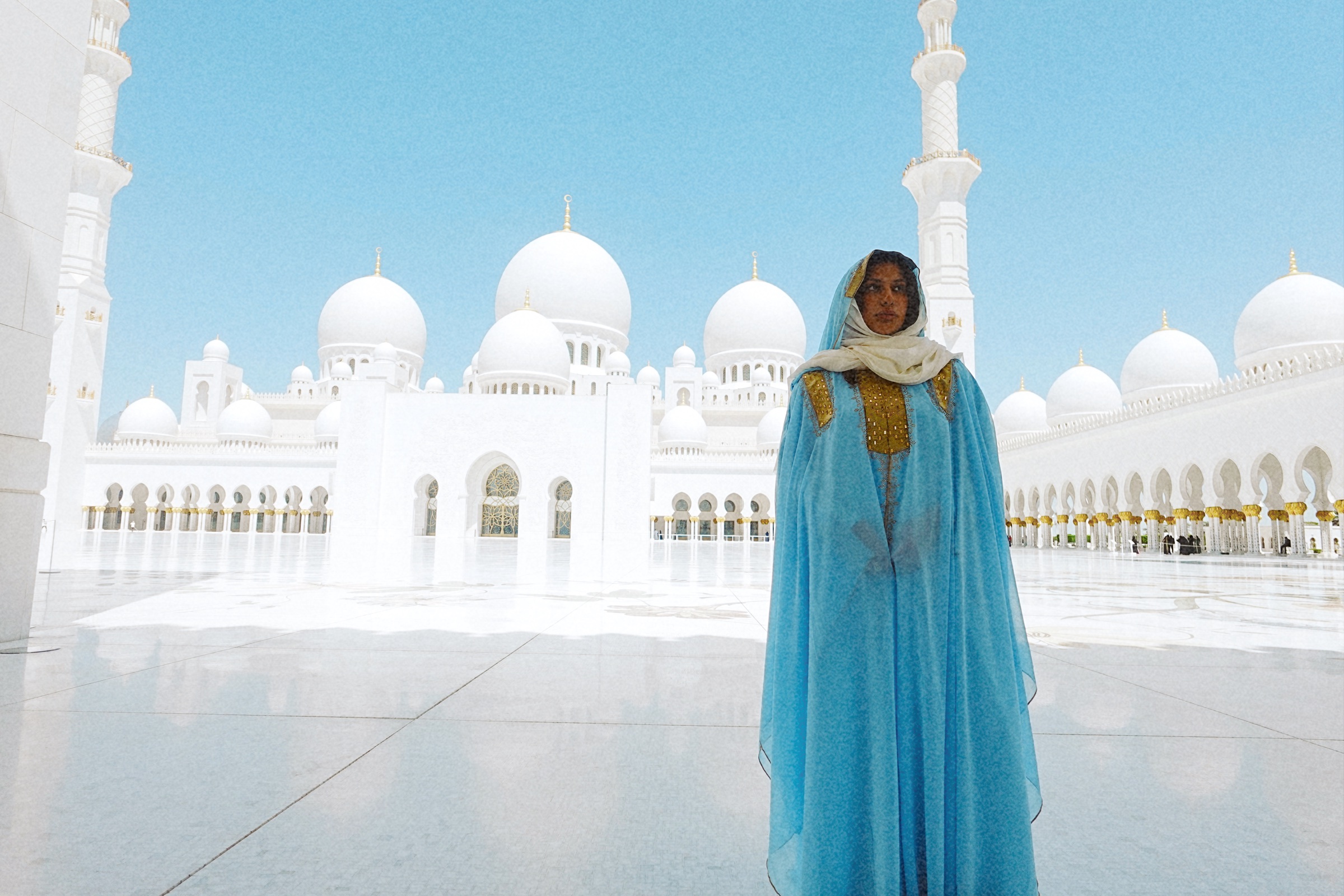 Portrait at Sheikh Zayed Grand Mosque with a turquoise garment against white architecture